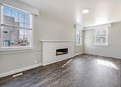 Thumbnail 7 of 19 - an empty living room with white walls and a fireplace