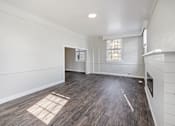 Thumbnail 5 of 19 - an empty living room with a fireplace and white walls