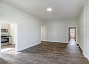Thumbnail 8 of 19 - an empty living room with white walls and wood flooring