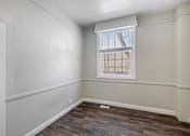 Thumbnail 18 of 19 - an empty room with wood flooring and a window