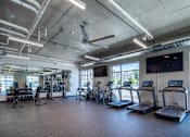 Thumbnail 18 of 36 - A spacious gym with treadmills, exercise bikes, and other equipment.