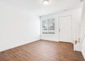 Thumbnail 14 of 17 - an empty living room with white walls and wood flooring