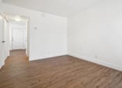 Thumbnail 12 of 17 - an empty living room with white walls and wood flooring