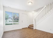 Thumbnail 15 of 17 - an empty living room with a staircase and a window