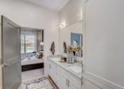 Thumbnail 10 of 23 - Bathroom vanity with dual sinks and granite countertop at The Mill Old Town Apartments, Lewisville, TX 75057