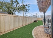 Thumbnail 14 of 19 - the backyard has a fenced in area with artificial grass and benches