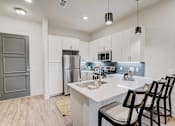 Thumbnail 17 of 19 - a kitchen with a white counter top and a stainless steel refrigerator