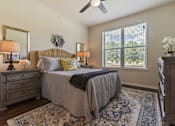 Thumbnail 9 of 16 - Spacious bedroom at Auberge of Tyler apartments in Tyler TX with ceiling fan and natural light.