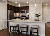 Thumbnail 14 of 24 - Spacious kitchen with a center island, bar seating, and stainless steel appliances at Auberge of Tyler.