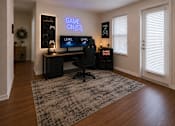 Thumbnail 19 of 24 - Flexible den staged as a gaming room or media space in a one-bedroom apartment at Auberge of Tyler.