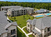 Thumbnail 5 of 24 - Aerial view of the apartment buildings, green spaces, and covered parking at Auberge of Tyler.