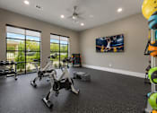 Thumbnail 7 of 24 - Fitness center with exercise equipment, large windows, televisions, and open workout space at Auberge of Tyler.