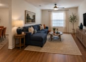 Thumbnail 15 of 24 - Stylish living room with comfortable seating, entertainment area, and wood-style flooring at Auberge of Tyler.
