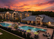 Thumbnail 1 of 24 - Resort-style pool at sunset with beautifully lit apartment homes at Auberge of Tyler.