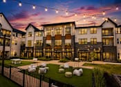 Thumbnail 23 of 47 - Outdoor courtyard with lawn games and string lights at The Bluewood Kerrville