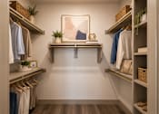 Thumbnail 3 of 32 - Large walk-in closet with built-in shelving, hanging space, and organized storage in a luxury apartment at One Preston Station in Celina, TX.