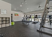 Thumbnail 12 of 16 - A gym with a variety of equipment including weights and machines.
