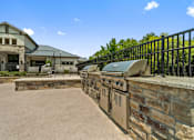 Thumbnail 2 of 16 - Outdoor grilling station with stone surround at Auberge of Tyler apartments in Tyler TX.