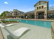 Thumbnail 1 of 16 - Pool area at Auberge of Tyler apartments in Tyler TX with sun deck.