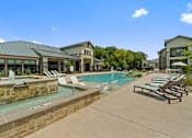 Thumbnail 10 of 16 - Swimming pool and stone feature wall at Auberge of Tyler apartments in Tyler TX.