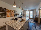 Thumbnail 15 of 35 - a kitchen with granite countertops and a view of the living room at One Preston Station, Celina, 75009