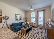 Thumbnail 6 of 35 - a living room with a blue couch and a brown coffee table at One Preston Station, Celina