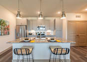 Thumbnail 34 of 35 - a kitchen with an island and three stools