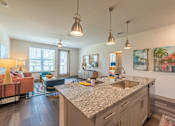 Thumbnail 8 of 35 - a kitchen with an island and a living room in the background at One Preston Station, Texas, 75009