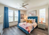 Thumbnail 14 of 35 - a bedroom with a bed and a ceiling fan at One Preston Station, Celina, TX, 75009