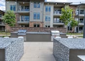 Thumbnail 5 of 35 - an outdoor barbecue area with two grills at the whispering winds apartments in pearland, tx at One Preston Station, Celina, 75009