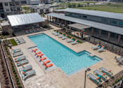 Thumbnail 1 of 35 - an aerial view of a swimming pool with chaise lounge chairs and a building in the background at One Preston Station, Celina