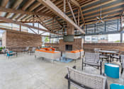 Thumbnail 3 of 35 - a patio with couches and chairs and a fireplace at One Preston Station, Texas, 75009