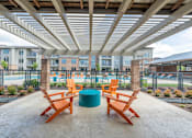 Thumbnail 2 of 35 - a patio with a table and chairs and a pool in the background at One Preston Station, Texas