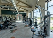 Thumbnail 10 of 35 - a gym with cardio equipment and a large window at One Preston Station, Celina