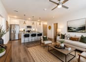 Thumbnail 2 of 32 - Open-concept apartment living room with a modern kitchen, large island, stainless steel appliances, and luxury finishes at One Preston Station in Celina, TX.