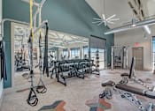 Thumbnail 13 of 32 - Modern apartment fitness center with cardio equipment and weights.