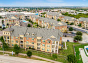 Thumbnail 1 of 19 - Aerial view of Auberge of Burleson apartments in Burleson TX with resort-style swimming pool and landscaped grounds.