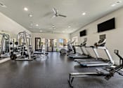 Thumbnail 12 of 19 - Fitness center with treadmills and ellipticals at Auberge of Burleson apartments in Burleson TX.