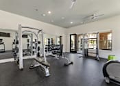 Thumbnail 13 of 19 - A spacious gym with a variety of equipment including a squat rack, bench, and weights.