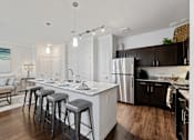 Thumbnail 8 of 19 - Modern kitchen with breakfast bar and granite countertops at Auberge of Burleson apartments in Burleson TX.