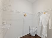 Thumbnail 11 of 19 - A white bathroom with a white robe hanging on the wall.