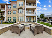 Thumbnail 14 of 19 - Clubhouse patio seating area and fire pit at Auberge of Burleson luxury apartments in Burleson TX.