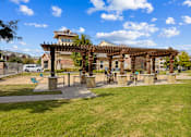 Thumbnail 15 of 19 - Pergola seating and green space at Auberge of Burleson apartments in Burleson TX.