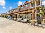 Thumbnail 3 of 19 - A sunny day at a residential complex with a pool and a covered patio area.
