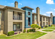Thumbnail 1 of 23 - a row of townhomes with balconies and grass and a sidewalk