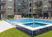 Thumbnail 19 of 19 - A swimming pool in front of apartment buildings.