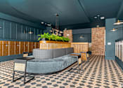 Thumbnail 2 of 23 - Modern mail room lobby with seating and planters at The Mill Old Town Apartments, Lewisville
