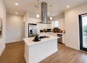 Thumbnail 13 of 23 - Open-concept kitchen with oversized island, quartz countertops, and modern cabinetry at The Mill Old Town Apartments.
