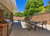Thumbnail 30 of 38 - a patio with tables and chairs and a barbecue grill