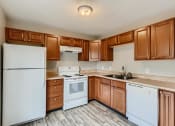 Thumbnail 4 of 17 - A kitchen with a refrigerator, range oven, dishwasher, and cabinets at Alder Square Townhomes Apartments
